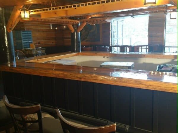 Construction Project by DCB Construction Sacramento Interior of a restaurant bar with polished would countertops and lantern style lighting in Sacramento CA