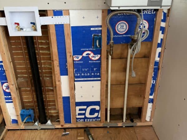 Construction Project by DCB Construction Sacramento Opened up wall showing plumbing and electricity for a washer and dryer laundry room setup in Sacramento CA