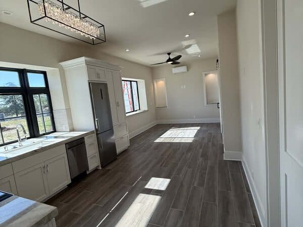 Kitchen Remodeling by DCB Construction Sacramento Open-concept of kitchen/dining room with wood floor and professionally remodeled walls and cabinets, clean fan and decorative lighting for a home or ADU in Sacramento CA